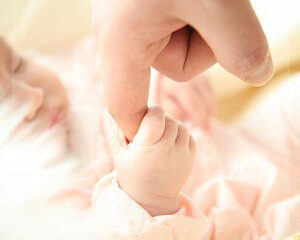 noworodek trzyma palec rodzica
